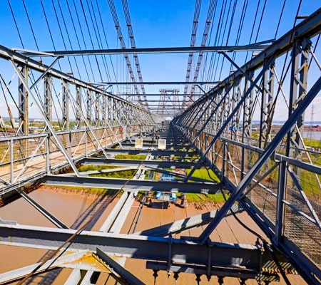 Estructura de puente en construcción sobre un río hecha con metales ferrosos
