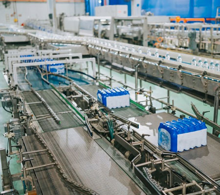 Cinta transportadora industrial al interior de una fábrica embotelladora de agua potable